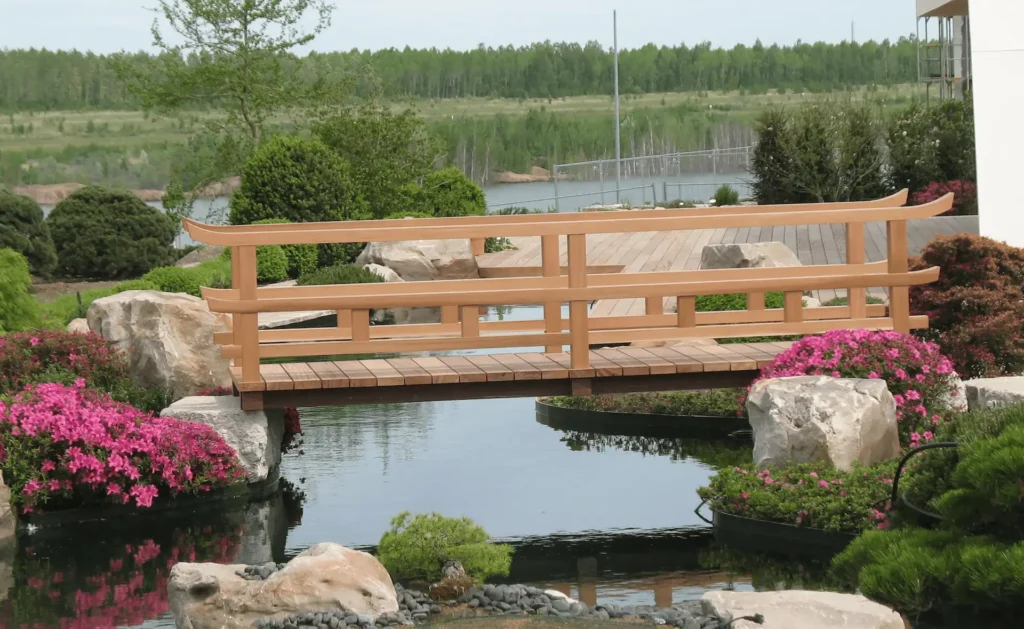 Holzbruecke in einem japanischen Garten ueber Wasserlauf